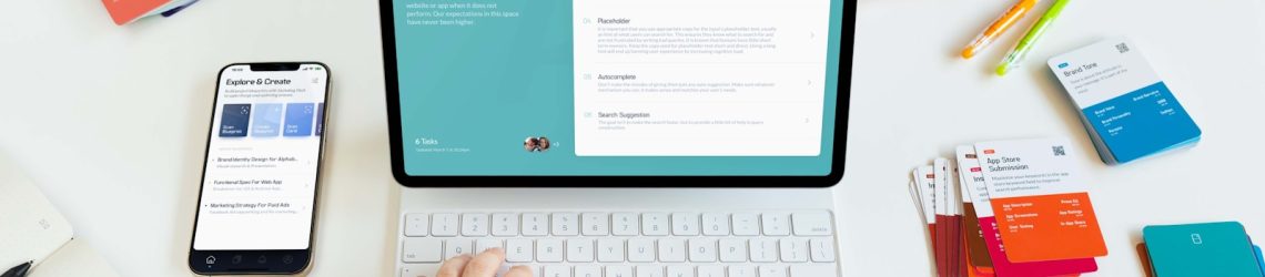 a person typing on a laptop next to a phone
