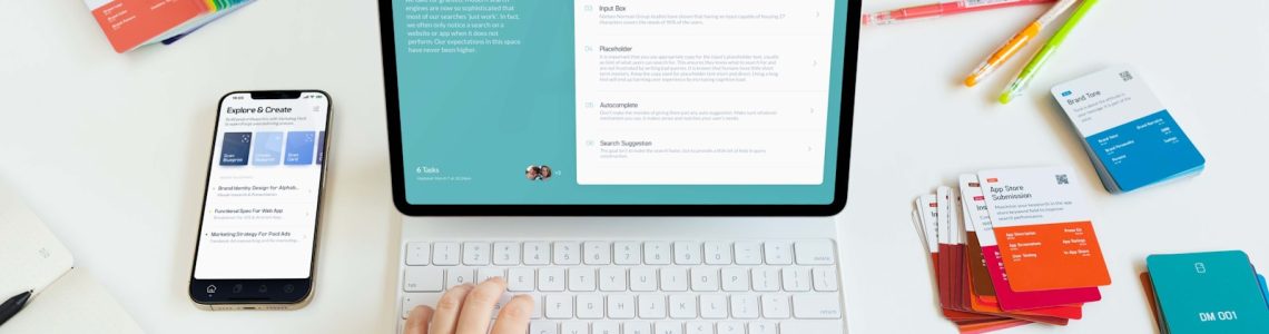 a person typing on a laptop next to a phone
